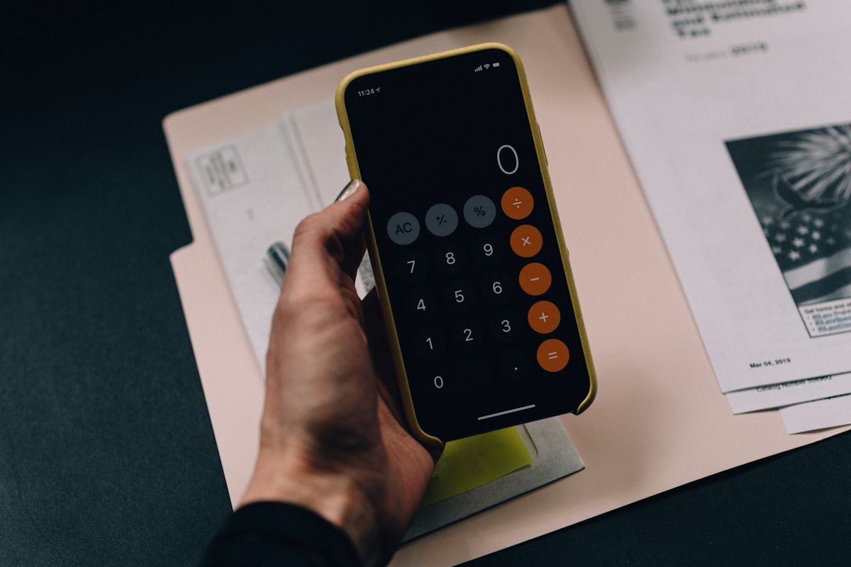 Calculadora, documentos y monedas ilustrando el pago de una hipoteca